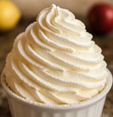 Une crème chantilly au mascarpone est servie dans un bol en verre.